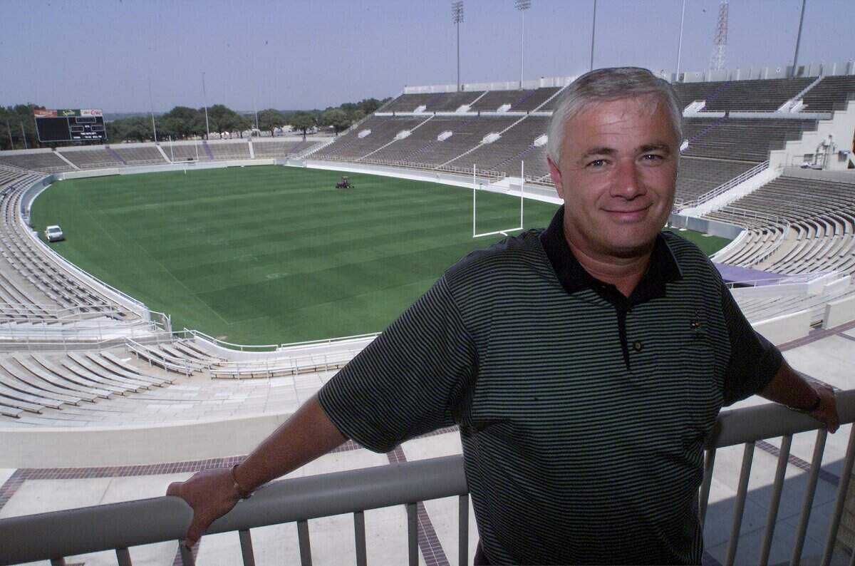 Pelatih kepala sepak bola TCU Dennis Franchione bersandar di pagar di luar kantornya yang menghadap ke lapangan permainan di Stadion Amon G. Carter pada 5 September 2000, di Fort Worth.