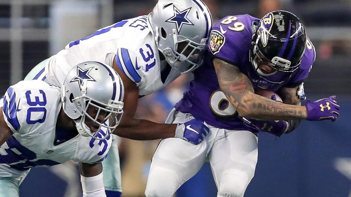 Safety Byron Jones, center, corralling Ravens receiver Steve Smith, led the Cowboys with eight tackles Sunday.
