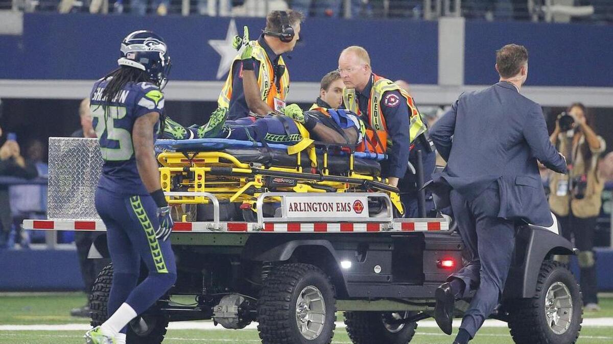Seahawks receiver Ricardo Lockette (83) is carted off the field after suffering a concussion on a hit by Jeff Heath.