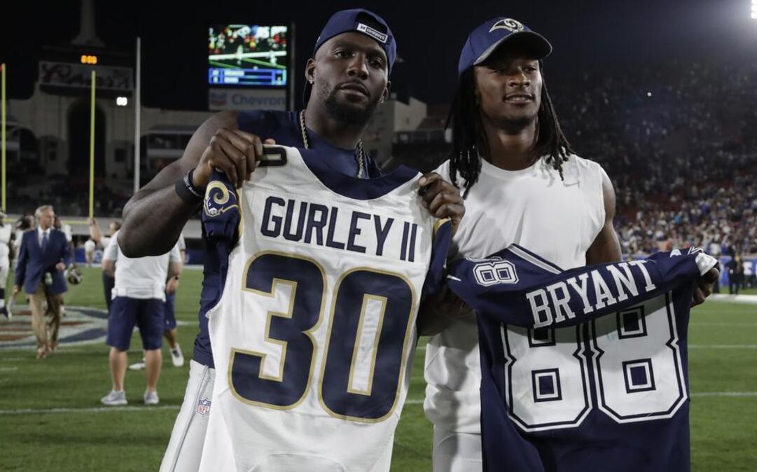 Los Angeles Rams running back Todd Gurley, right, and Dallas Cowboys wide receiver Dez Bryant, left hold each other's jerseys after trading on the field following a preseason NFL football game, Saturday, Aug. 13, 2016, in Los Angeles. Bryant had two catches for 28 yards and a touchdown.