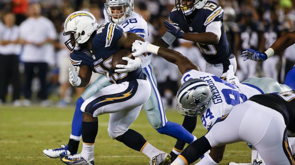 
San Diego Chargers running back Branden Oliver, left, breaks free from Dallas Cowboys defensive end Randy Gregory during Thursday’s preseason game.
