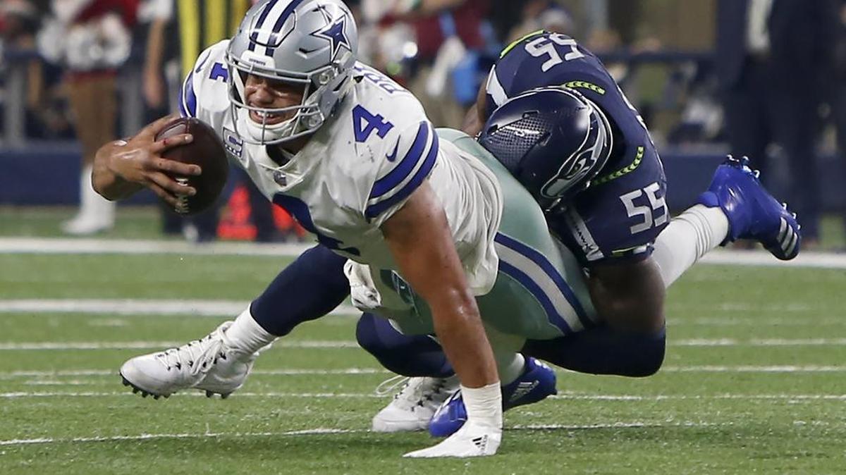 Dallas Cowboys quarterback Dak Prescott (4) is sacked by Seattle Seahawks defensive end Frank Clark (55) late in the second half of an NFL football game at AT&T Stadium in Arlington on Sunday.