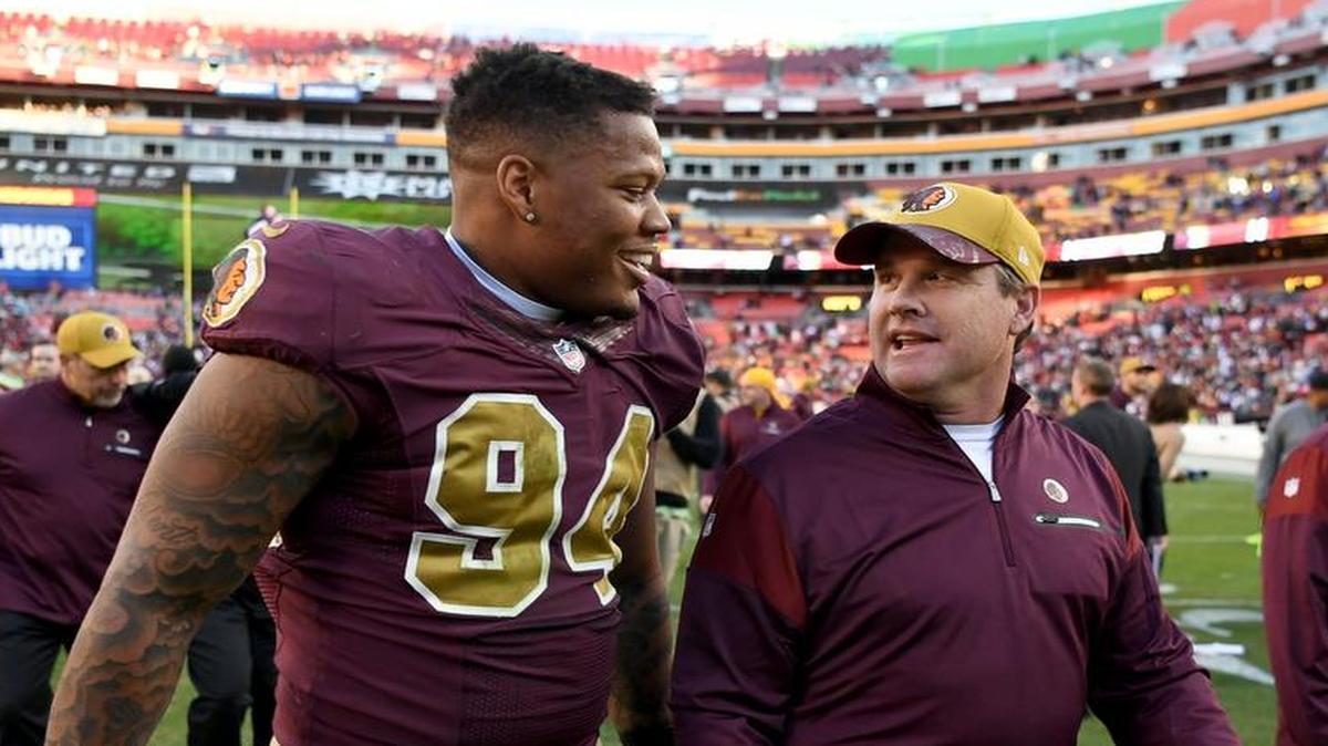 Washington Redskins head coach Jay Gruden walks off the field with linebacker Preston Smith (94) who made a key interception during fourth quarter action against the Minnesota Vikings at FedEx Field.