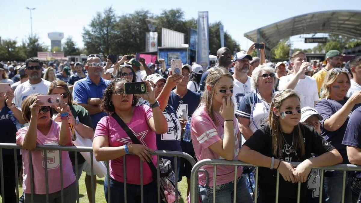Football fans gather in the west party zone to watch the Dallas Cowboys Cheerleaders before a game against the Green Bay Packers on Oct. 8, 2017 at AT&T Stadium.