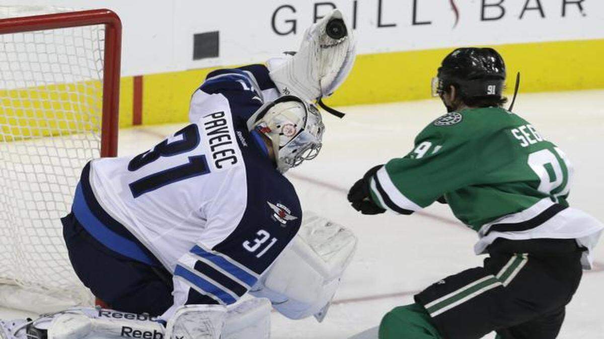 
 Jets goalie Ondrej Pavelec  makes one of his 46 saves, a third-period glove save against Stars center Tyler Seguin. 
