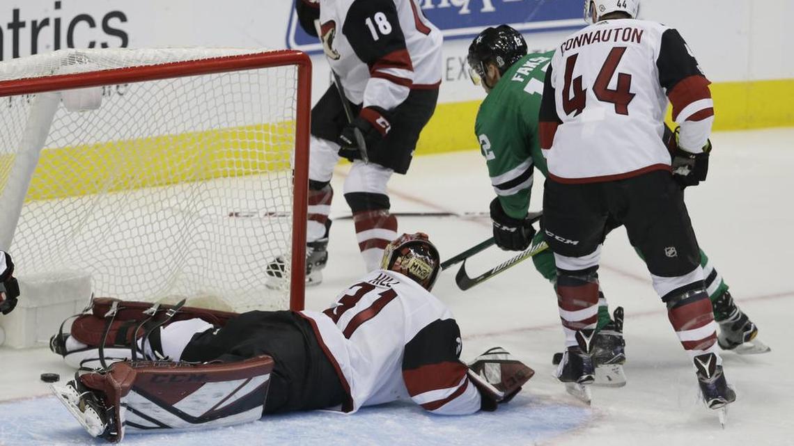 Dallas Stars center Radek Faksa (12) scores the first goal of the game despite the defense of Arizona Coyotes goalie Adin Hill (31), Kevin Connauton (44) and Christian Dvorak (18) during the first period Tuesday night in Dallas.