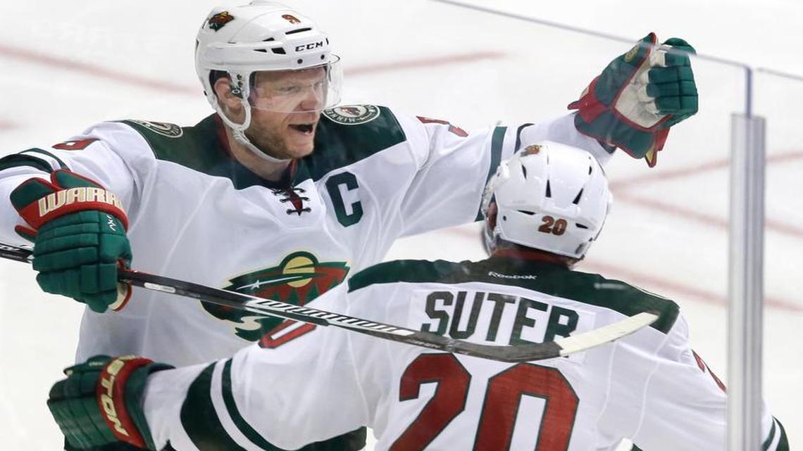 Minnesota Wild center Mikko Koivu (9) celebrates his goal with defenseman Ryan Suter (20) during overtime in Game 5 in the first round of the NHL Stanley Cup playoffs against the Dallas Stars on Friday, April 22, 2016, in Dallas. The Wild won 5-4.