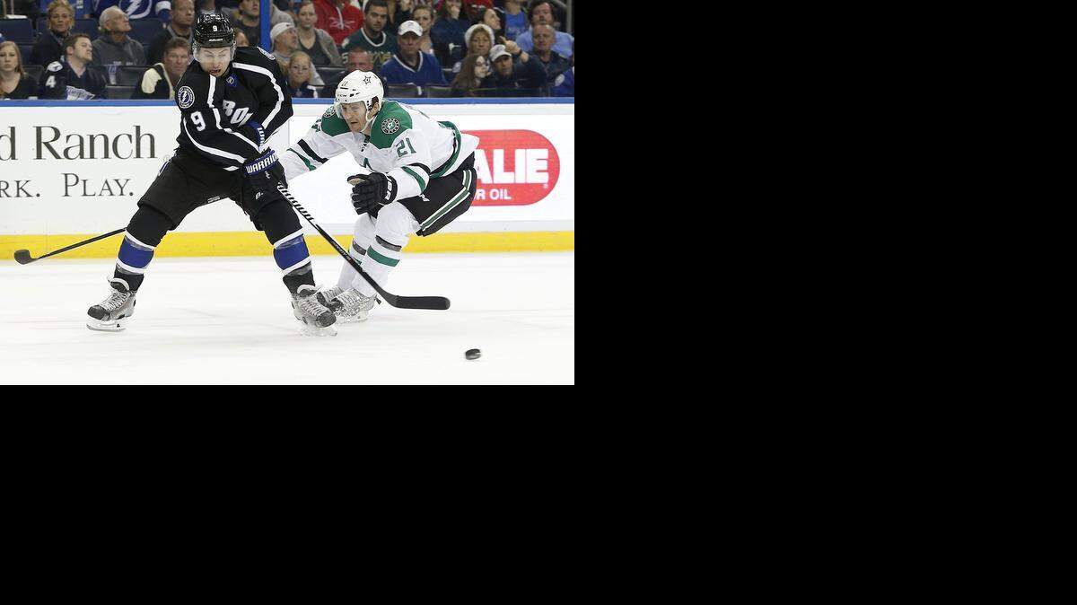 
Lightning center Tyler Johnson, left, works to keep the puck away from Stars left wing Antoine Roussel.


