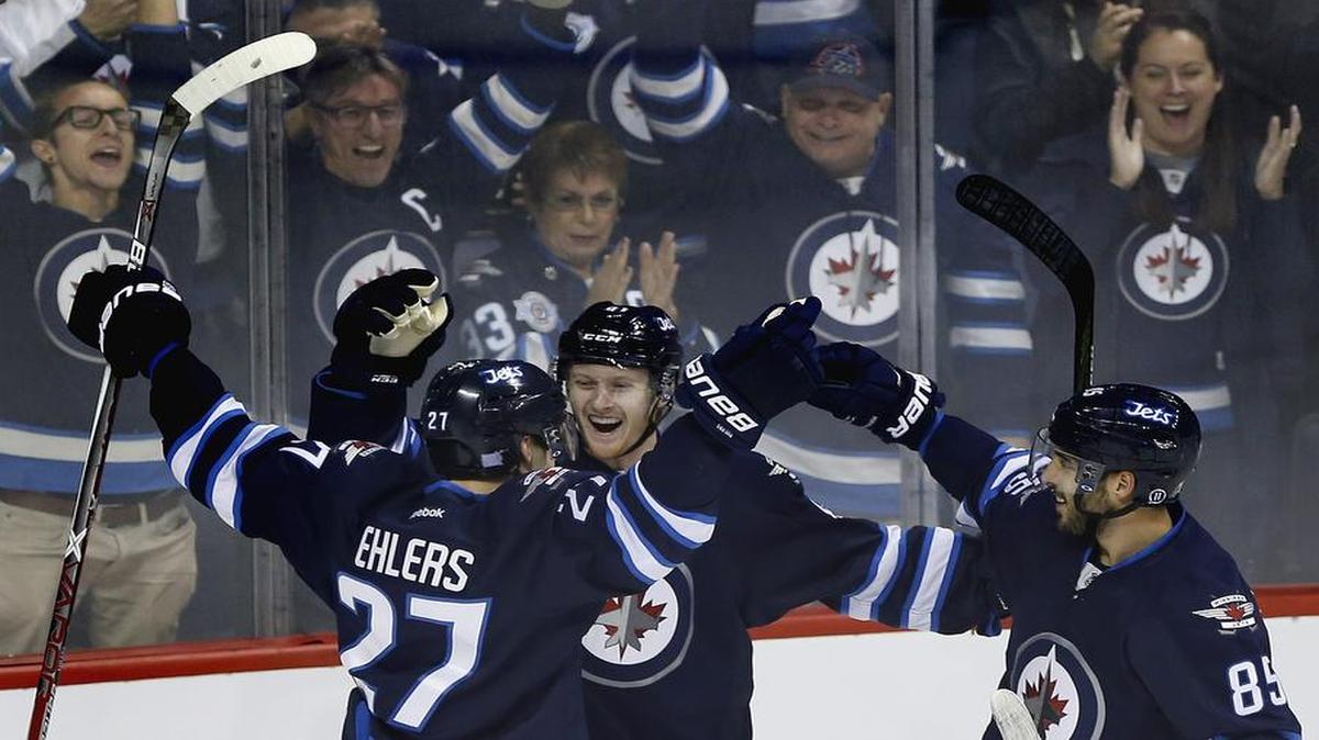 Kyle Connor, center, celebrates his first NHL goal with Winnipeg teammates Nikolaj Ehlers, left, and Mathieu Perreault in the Jets’ 4-1 victory over the Dallas Stars on Oct. 27. The teams meet for the third time this season Tuesday in Winnipeg.
