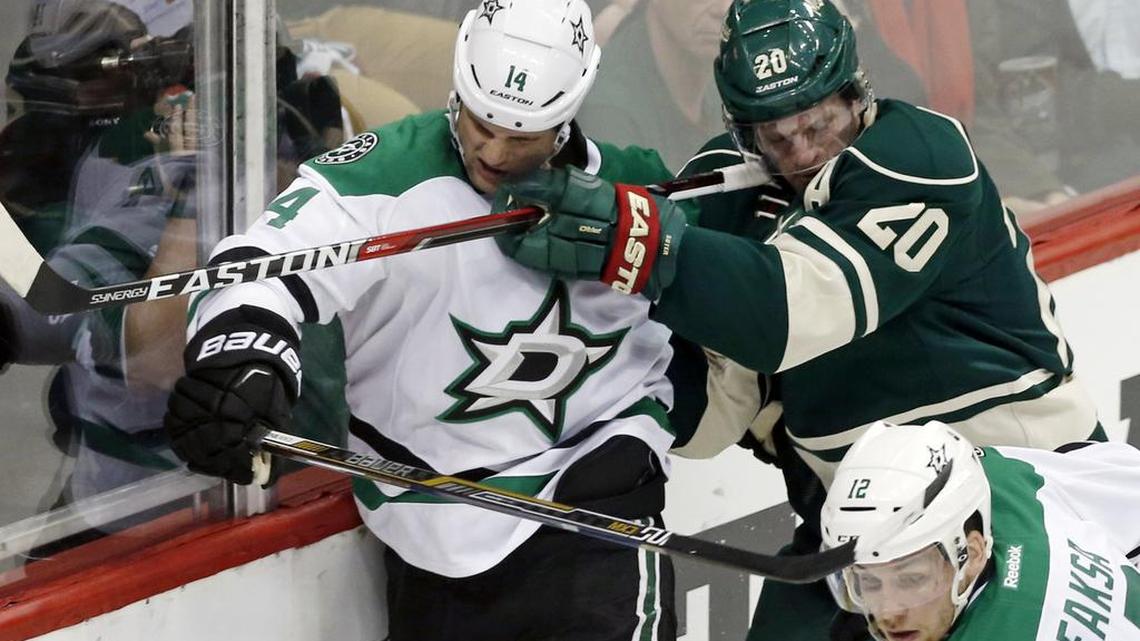 Stars captain Jamie Benn, left, gets a face full of stick courtesy of Minnesota’s Ryan Suter during Wednesday’s Game 4 of their first-round playoff series. Dallas won 3-2 and brings a commanding 3-1 series lead into Friday’s home game.