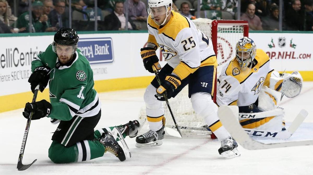 Dallas Stars left wing Curtis McKenzie, left, attempts to gain control of the puck as Nashville Predators’ Alexei Emelin (25) and goalie Juuse Saros (74) watch during the first period Tuesday in Nashville.