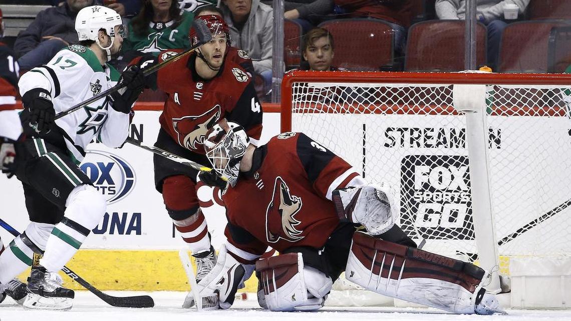 Stars center Devin Shore (17) flips the puck up and over Arizona Coyotes goaltender Scott Wedgewood, right, for a goal as Coyotes defenseman Niklas Hjalmarsson (4) watches in Thursday night’s game in Glendale, Ariz.