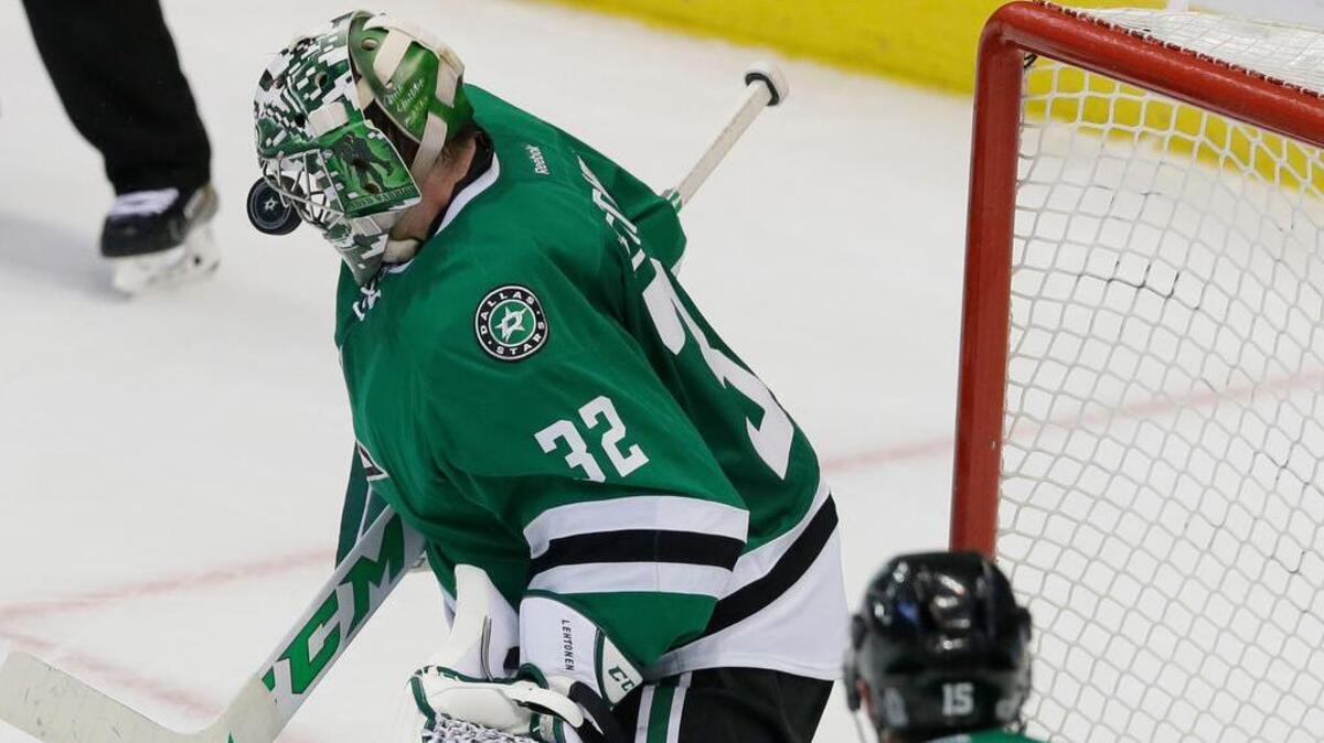 Dallas Stars goalie Kari Lehtonen (32) deflects a shot with his mask as defenseman Patrik Nemeth (15) looks on during the third period of an NHL hockey game against the San Jose Sharks in Dallas, Monday, March 20, 2017. The Stars won 1-0.