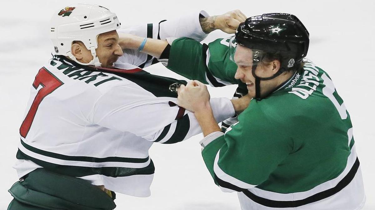 Stars defenseman Jamie Oleksiak, right, mixes it up with Minnesota Wild forward Chris Stewart during Monday’s game. The Stars, who won 3-2 in overtime, take on the Predators on Wednesday in Nashville.