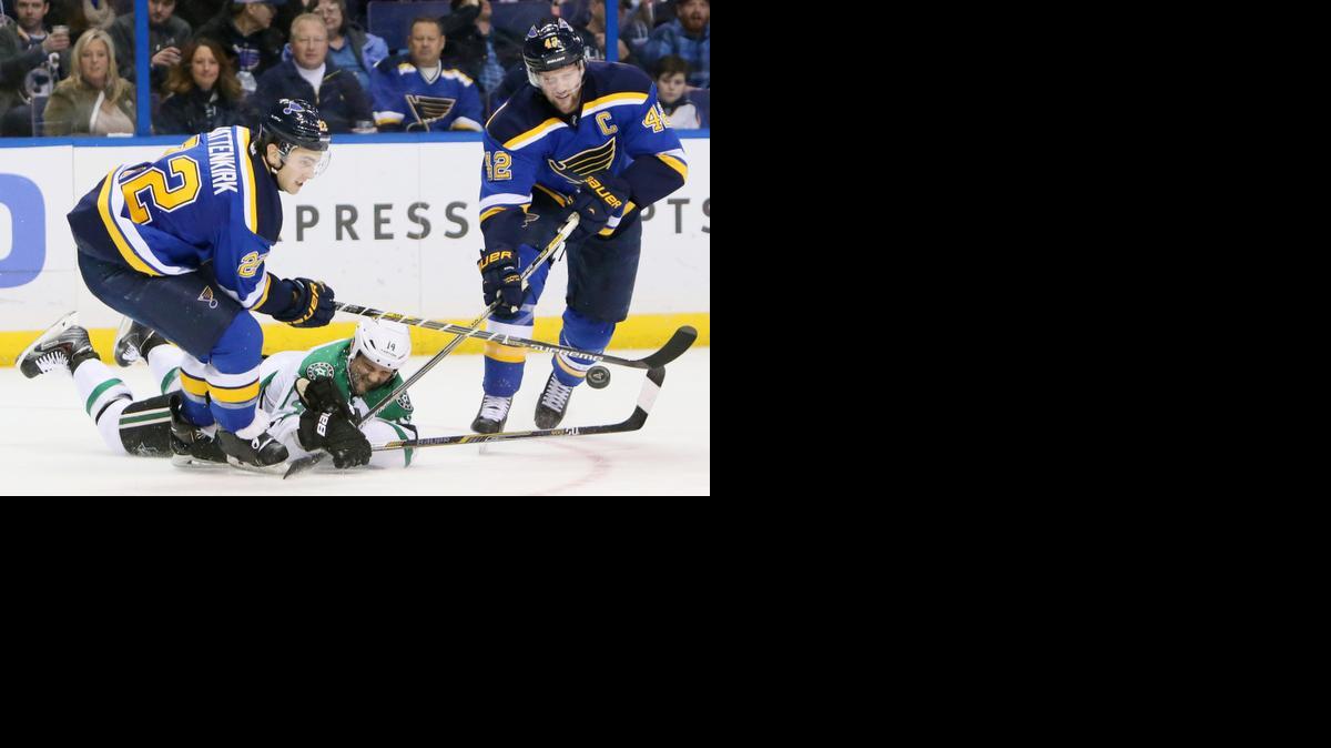 
The Dallas Stars’ Jamie Benn, middle, dives after the puck between the St. Louis Blues’ Kevin Shattenkirk, left, and David Backes in second-period action on Saturday, Dec. 27, 2014, at the Scottrade Center in St. Louis. The Stars won, 4-3. 

