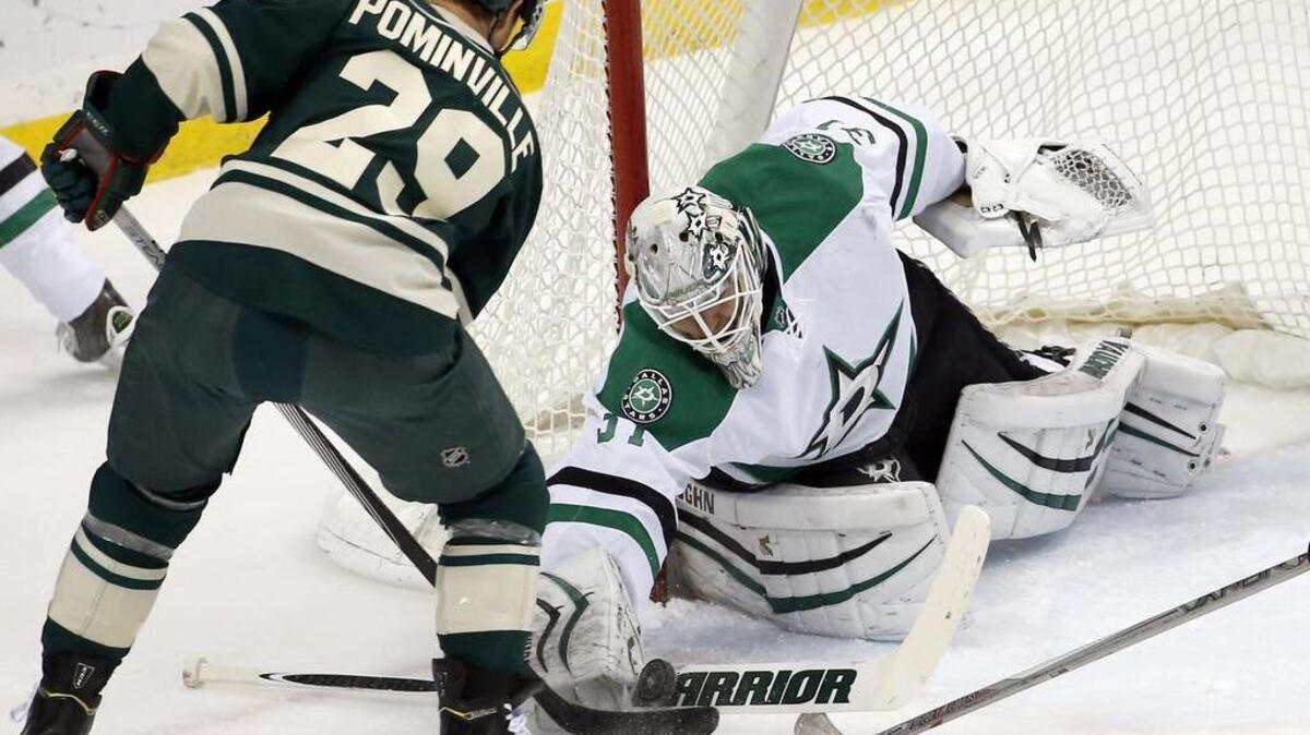 Stars goalie Antti Niemi, playing for the second day in a row, swats away a shot by Wild right wing Jason Pominville during the first period.