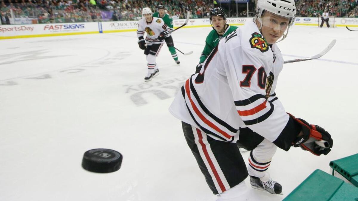 Chicago Blackhawks left wing Dennis Rasmussen chases the puck in front of Dallas Stars center Mattias Janmark during the first period of an NHL hockey game Saturday, Feb. 6, 2016, in Dallas.