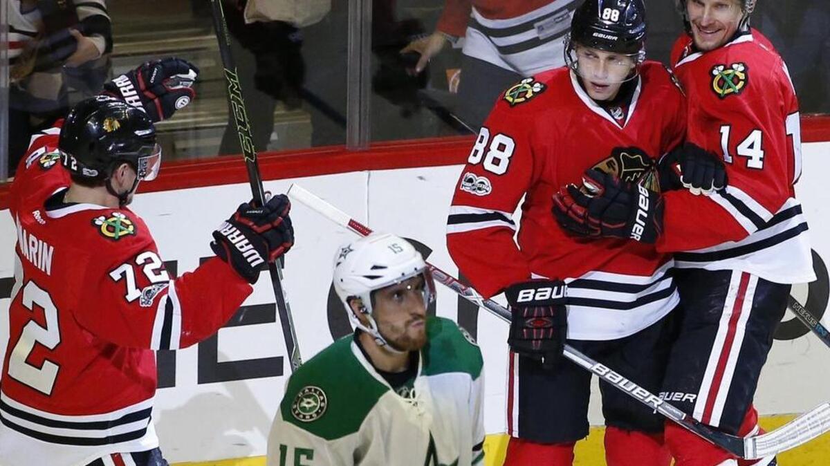 Chicago Blackhawks right wing Patrick Kane (88) celebrates a goal with left wing Richard Panik, right, and left wing Artemi Panarin, left, as Dallas Stars defenseman Patrik Nemeth walks away.