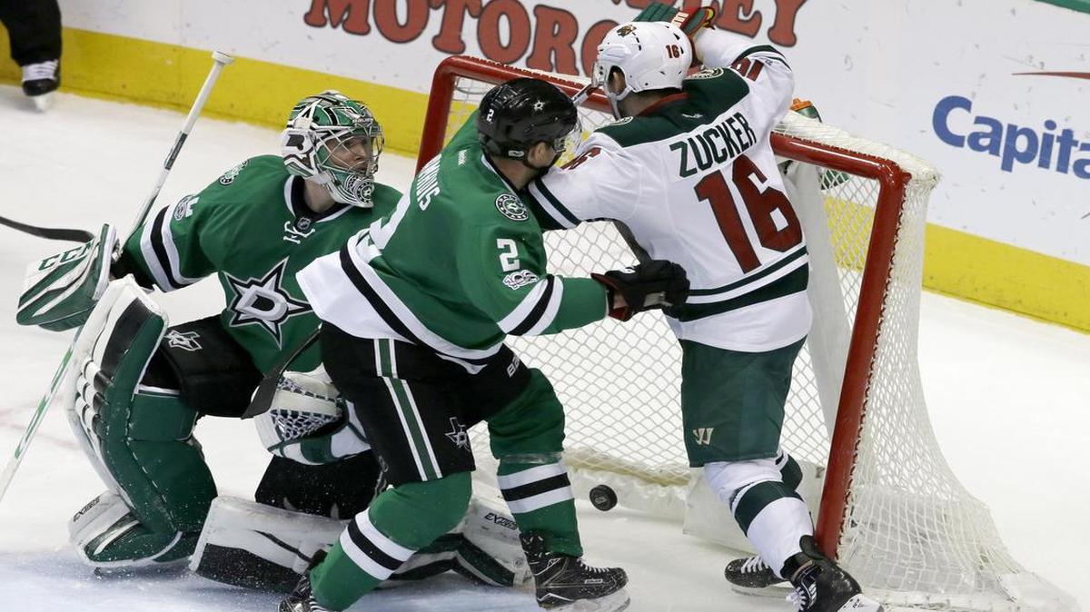 Jason Zucker, right, of the Minnesota Wild crashes into the net after scoring the game-deciding goal late in the third period. Stars defenseman Dan Hamhuis (2) and goalie Kari Lehtonen couldn’t stop him.