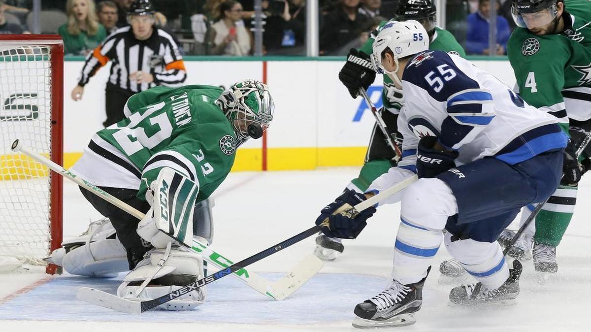 Stars goalie Kari Lehtonen takes a puck to the mask as he stops a shot from Jets’ Mark Scheifele in the second period.