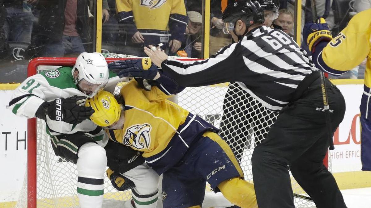 Dallas Stars center Tyler Seguin (91) and Nashville Predators left wing Filip Forsberg (9) fight inside the net as linesman Scott Driscoll (68) tries to break it up during the second period Wednesday.