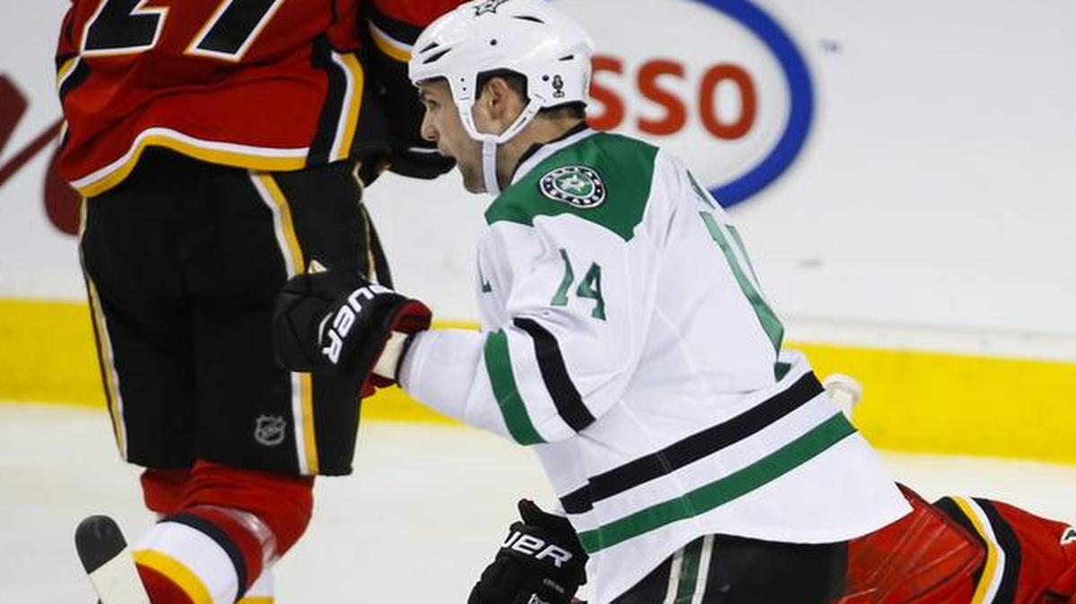 Stars winger Jamie Benn, left, celebrates his game-winning goal as Calgary Flames goalie Brian Elliott lies on the ice during the third period on Thursday night.