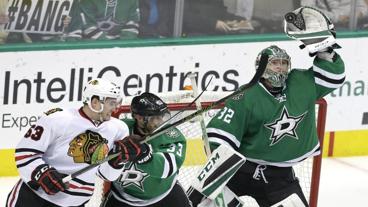 Stars goalie Kari Lehtonen goes high to snag a puck while defenseman Alex Goligoski keeps Blackhawks wing Brandon Mashinter away from the play. The top two Central Division teams have split their first two meetings and clash again Thursday in Chicago.