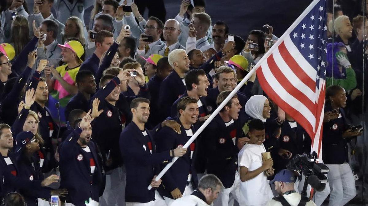 Michael Phelps carries the flag of the United States during the opening ceremony for the 2016 Summer Olympics in Rio de Janeiro, Brazil, Friday, Aug. 5, 2016.
