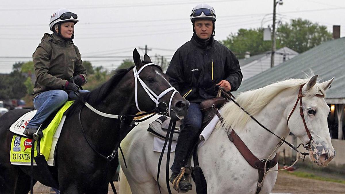 Trainer Joe Sharp, right, leads Kentucky Derby entrant Girvin, left, ridden by his wife, Rosie Napravnik, a former jockey, back to Barn 33 in May of 2017 following a morning gallop at Churchill Downs.