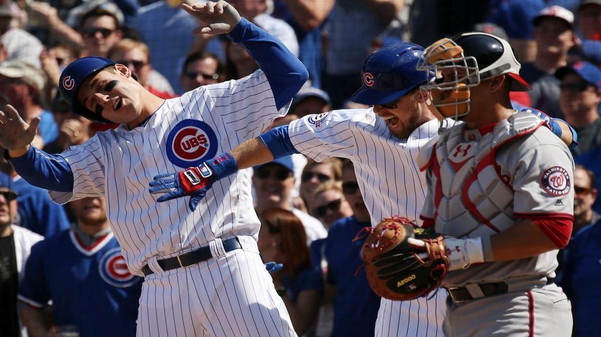 The Chicago Cubs’ Ben Zobrist, middle, celebrates with teammate Anthony Rizzo, left, after hitting a three-run home run in the fifth inning against the Washington Nationals at Wrigley Field in Chicago on Friday. The Cubs won 8-6. The Cubs and the Nationals play again at 3 p.m. Saturday on FS1.