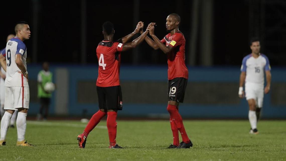 Trinidad and Tobago’s Kevan George, center right, and Kevon Villaroel celebrate as the U.S. team’s Bobby Wood, left, looks on after a World Cup qualifying match.