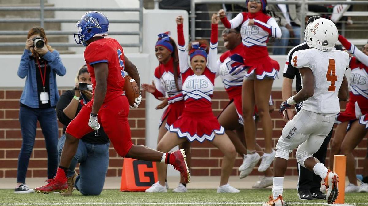 Duncanville running back Tre Siggers (5) rushes into the end zone past Arlington Bowie defensive back Deyshawn McGee (4) in the second half of high school playoff football action at Newsom Stadium in Mansfield, Texas on Saturday, Nov. 26, 2016. Duncanville won 32-27.