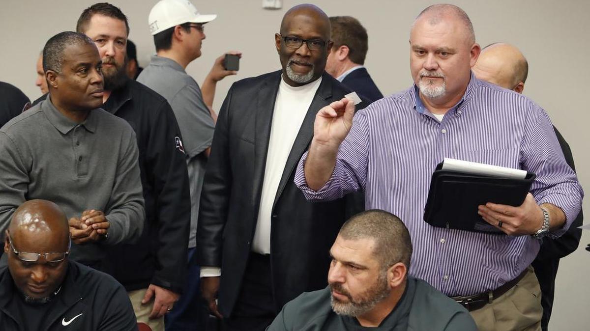 Paschal interim head football coach Michael Holcomb, right, shows his game opponent pick to District 4-6A coaches at the Birdville ISD Fine Arts/Athletics Complex during UIL realignment, Feb. 1, 2018.