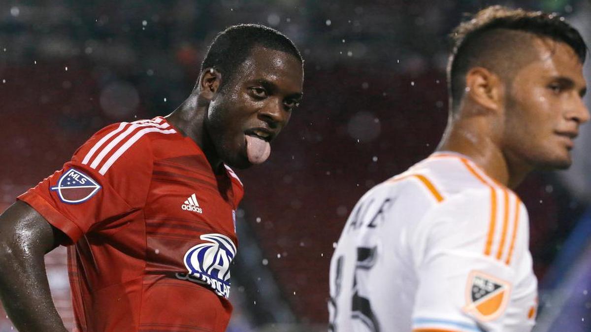 
FC Dallas midfielder Je-Vaughn Watson, left, sticks out his tongue as rain falls, after a play against Houston Dynamo midfielder Alexander Lopez (15) during the second half of an MLS soccer game in Frisco, Texas, Friday, June 26, 2015. Dallas won 2-0. 
