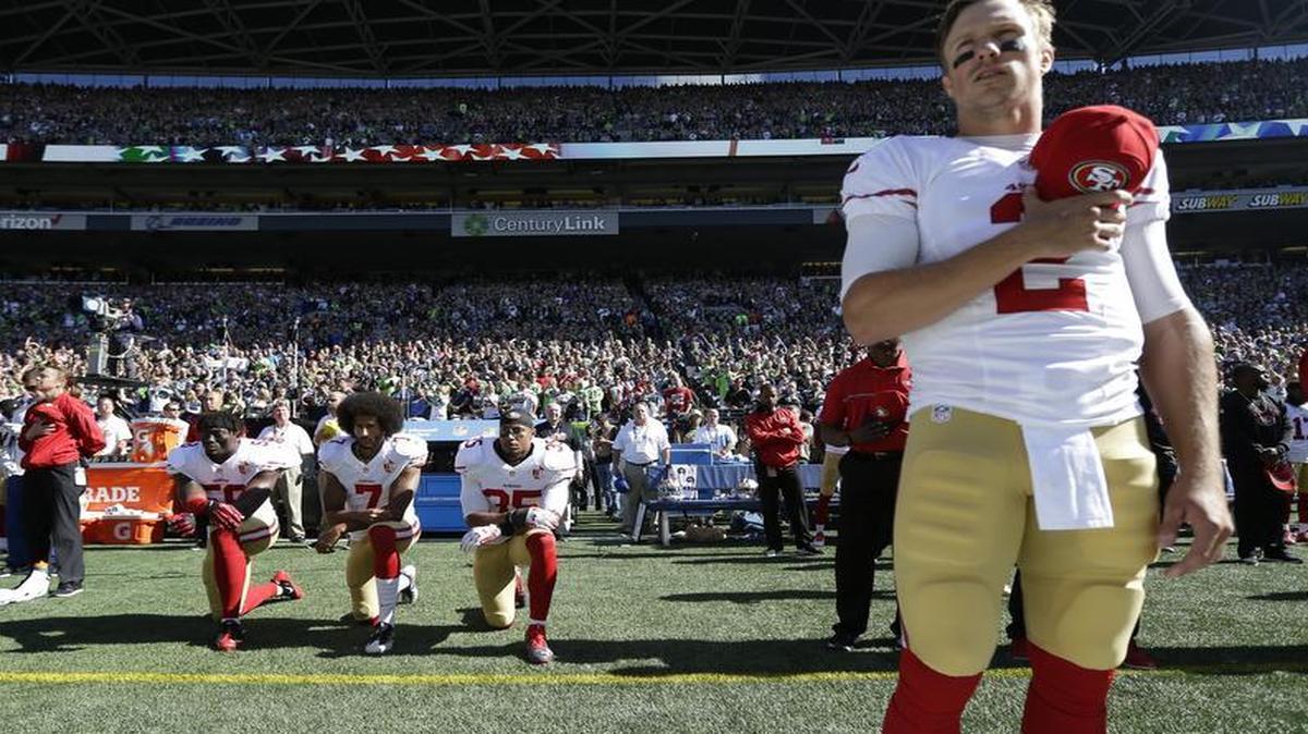 San Francisco 49ers quarterback Blaine Gabbert, right, stands as Eli Harold (58), Colin Kaepernick (7) and Eric Reid (35) kneel during the national anthem before an NFL football game against the Seattle Seahawks, Sunday, Sept. 25, 2016, in Seattle.