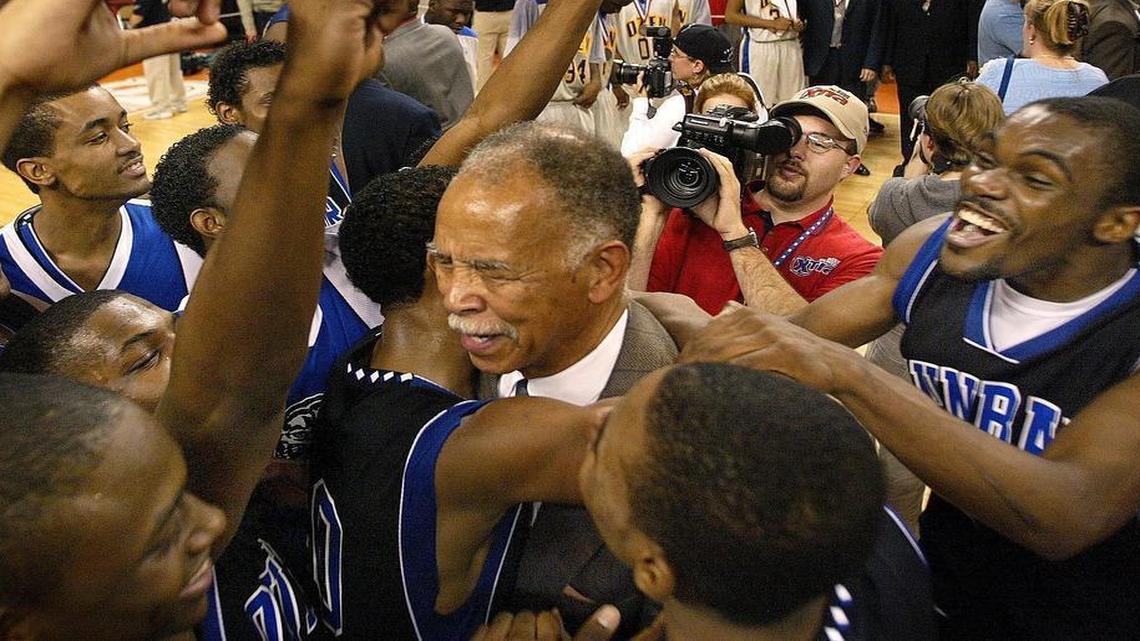 Former Dunbar coach Robert Hughes Sr., center, celebrates with his team after winning the 2003 Class 4A state title, the last of his five state championships, including three at I.M. Terrell.