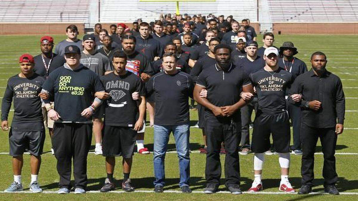 
The University of Oklahoma football team stands arm in arm Thursday on Owen Field in response to the recent racist video from a now-closed campus fraternity. In the front row, from left, are Sterling Shepard, Ty Darlington, Zack Sanchez, head coach Bob Stoops, Charles Tapper, Trevor Knight and Eric Striker. 
