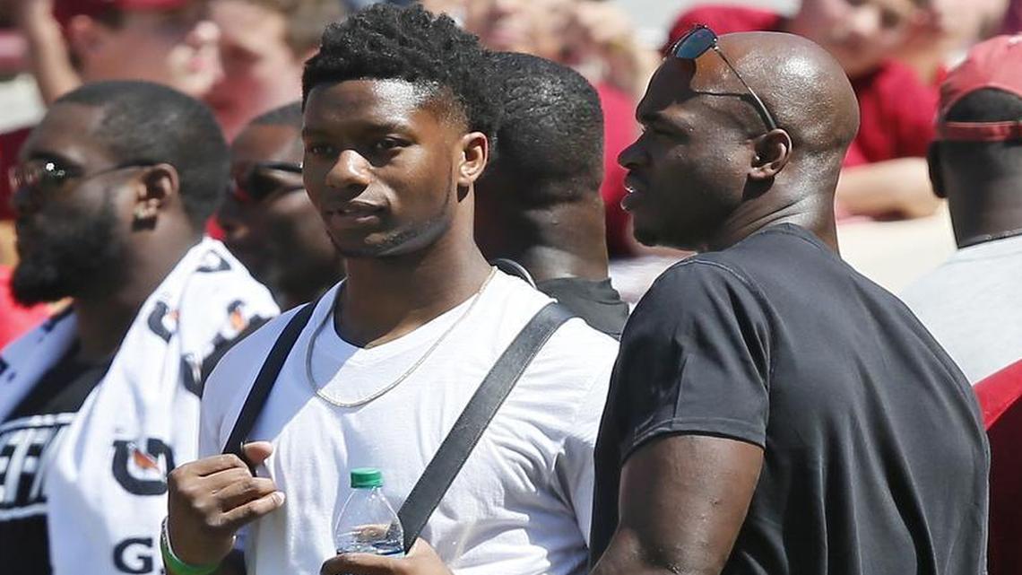 Former Oklahoma players Joe Mixon, left, and Adrian Peterson, right, talk during the Sooners’ spring game on April 8. Mixon is the latest complicated example of domestic violence abusers who was granted a second chance.