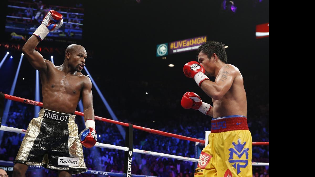 
Floyd Mayweather Jr., left, celebrates during his welterweight title fight against Manny Pacquiao. Mayweather won via unanimous decision.

