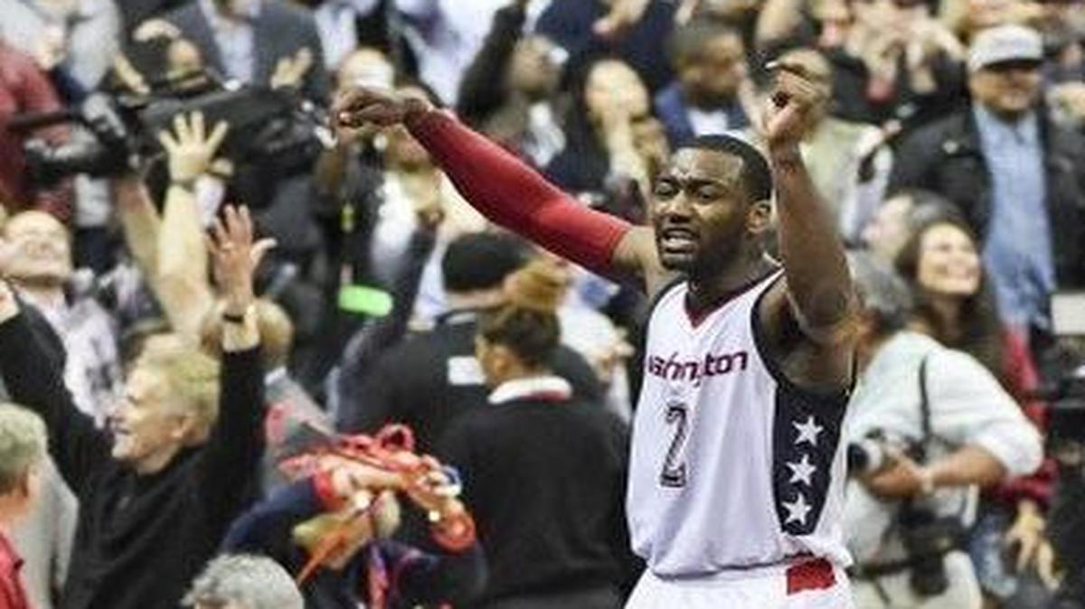 Washington Wizards guard John Wall, right, celebrates his game-winning 3-pointer in Game 6 with fans at Verizon Center. The Wizards play the Boston Celtics in Game 7 of their Eastern Conference semifinals series at 7 p.m Monday on TNT.