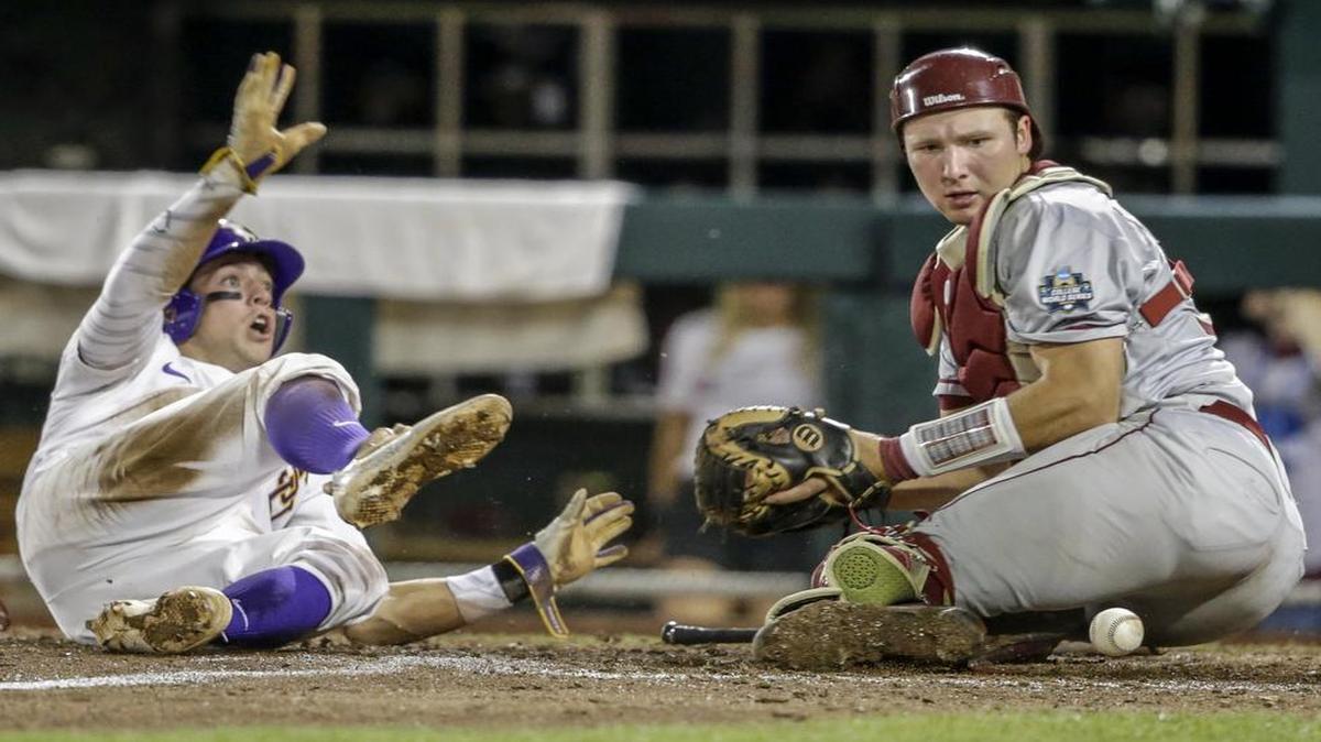 Cole Freeman, left, of LSU slides in with a run in Saturday’s 5-4 victory over catcher Cal Raleigh and Florida State in the College World Series in Omaha, Neb. The teams meet again in an elimination game at 6 p.m. Wednesday on ESPN.