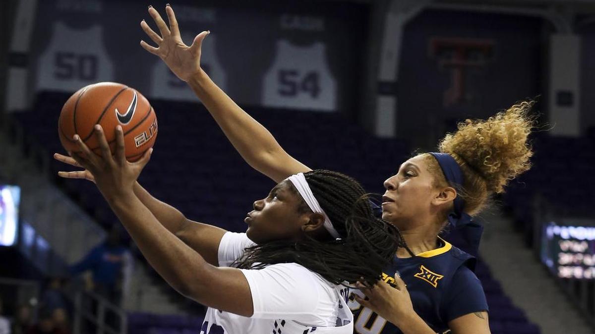 Amy Okonkwo, left, drives past West Virginia’s Desiree Rhodes toward the basket during Thursday’s loss at home. The Horned Frogs, still seeking their first Big 12 victory, play host to Oklahoma State on Wednesday at Schollmaier Arena. The game will be televised at 8 p.m. on FSSW Plus.