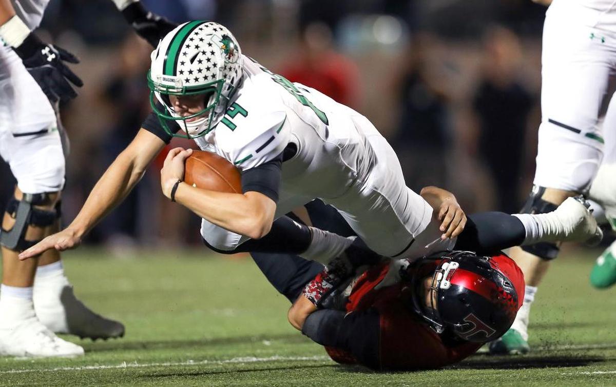 Southlake Carroll quarterback Will Bowers (14) is brought down by Trinity defensive end Isaiah Munoz during the first half, Friday night, October 6, 2017 played at Pennington Field in Bedford.