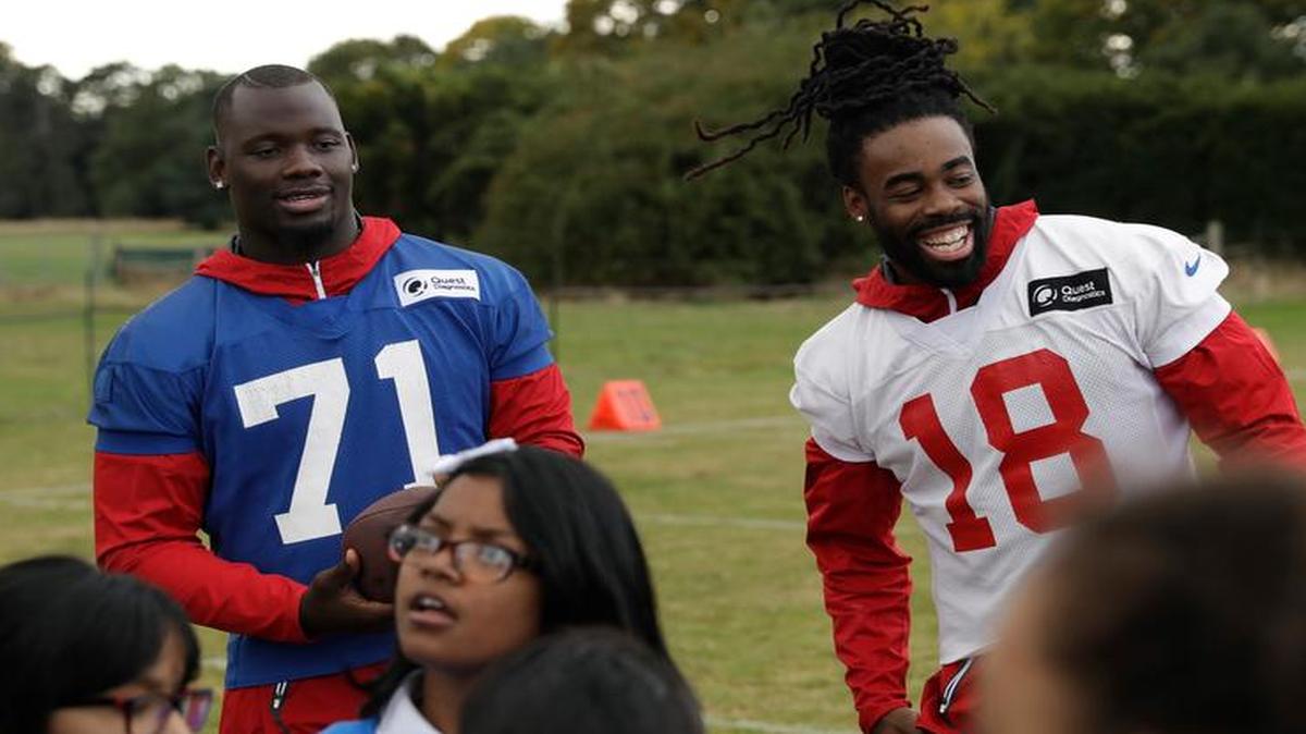 New York Giants practice squad players defensive end Stansly Maponga (71), a former TCU player, and wide receiver Geremy Davis (18) take part in an NFL community event with children at Syon House in Syon Park, south west London, Friday, Oct. 21, 2016. The Los Angeles Rams are due to play the New York Giants at Twickenham stadium in London on Sunday in a regular season NFL game. (AP Photo/Matt Dunham)